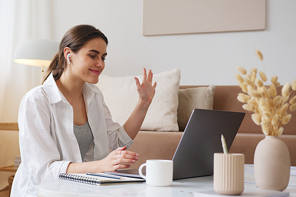 woman looking at laptop and waving